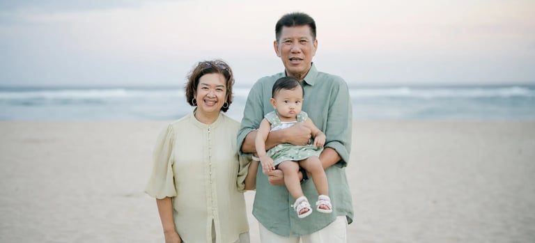 Grandmother standing with her grandchild during a multigenerational family photography session on a Bali beach.