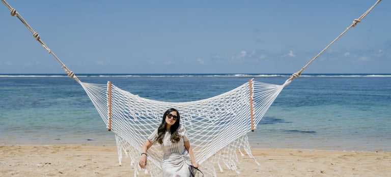 Woman sitting on a beach hammock at Samabe Bali Suites & Villas in Nusa Dua.