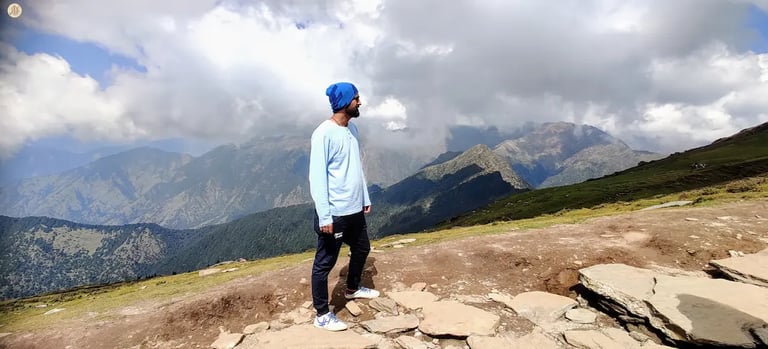 Clouds casting playful shadows on Himalayan mountains, Uttarakhand, serene alpine landscape.