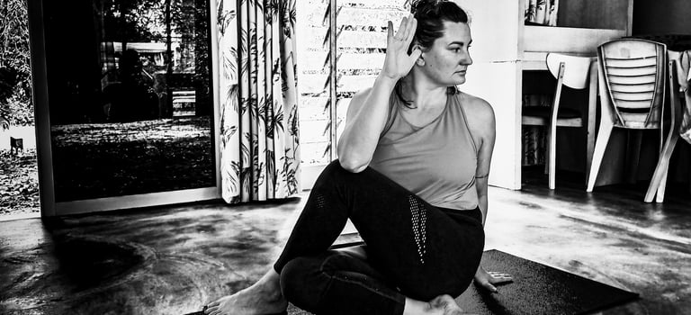 A woman performs a yoga pose - Ardha Matsyendrasana, or Half Lord of the Fishes Pose,