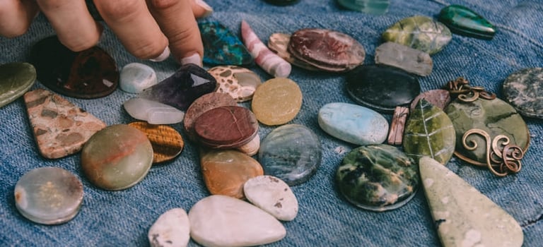 Mano eligiendo piedras naturales pulidas y cabujones de cristal