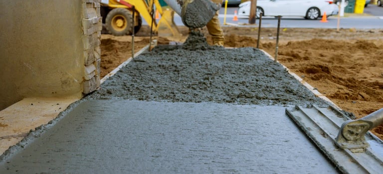 a man is laying concrete on the ground