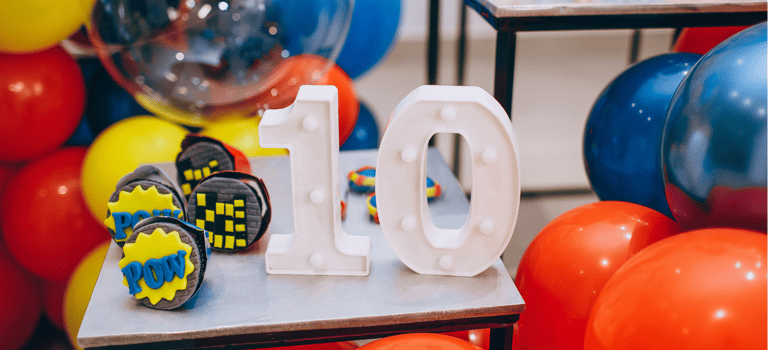une décoration d'anniversaire avec des ballons colorés et le chiffre 10 au centre