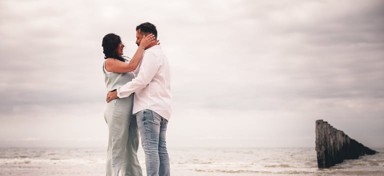 Un homme et une femme enlacés sur la plage