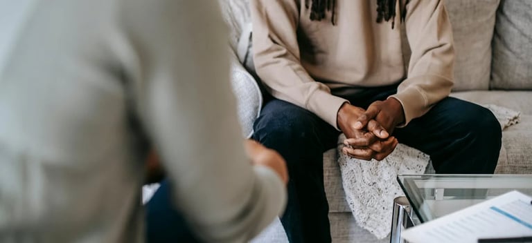 buste et main de deux personnes assises face à face