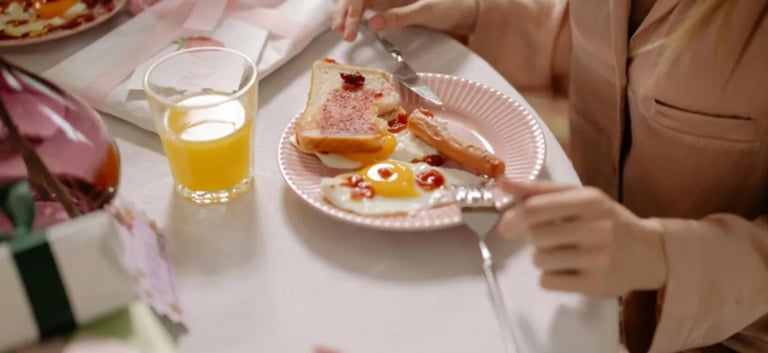 Uma mulher sentada a uma mesa com um prato de ovos, pão integral e suco de laranja 