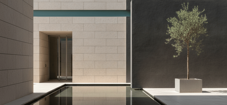 Modern minimalist courtyard featuring a reflecting pool, limestone walls, and an olive tree.