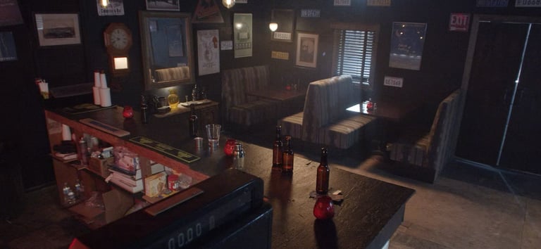 Bar room set at Grayfox Studios with counter, bottles, booths, and vintage wall decor