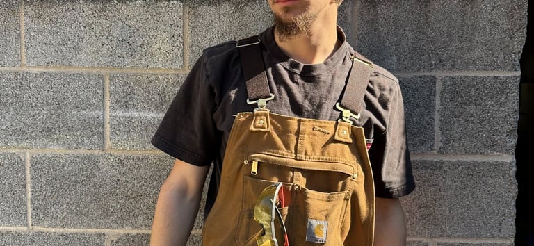jaspar schirmer standing by a wall in his welding gear