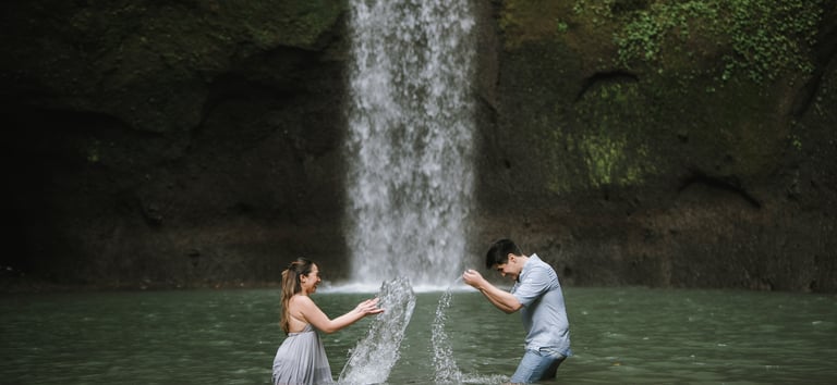 Intimate couple wide shot at Tibumana Waterfall in Bangli Bali