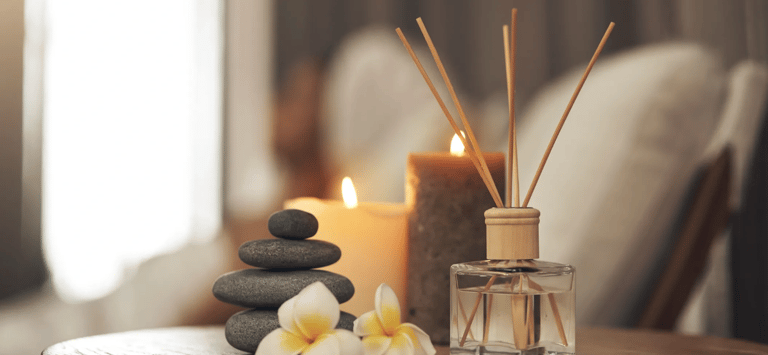 A medspa image of candles, incense, and balanced stones.