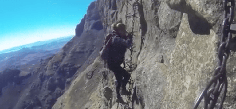Tracey Billington climbing the Sentinel Peak chain ladder walk, drakensberg, South Africa