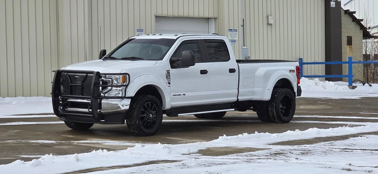 a white truck parked in front of a building after detailing