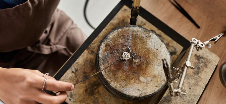 Joyero soldando un anillo de plata con soplete en el taller.