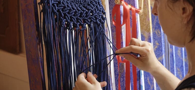 Mujer tejiendo collar de macrame 