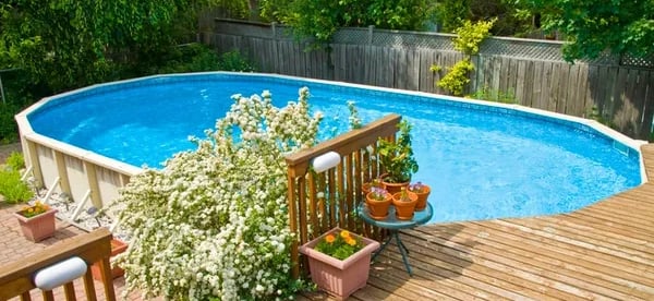 an above ground pool with a custom built deck with stairs