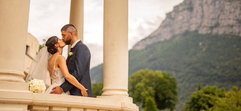 a bride and groom standing on a balcony