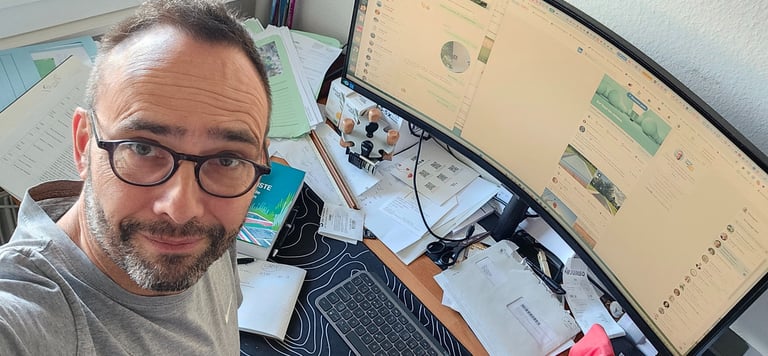  a man wearing glasses works on his computer