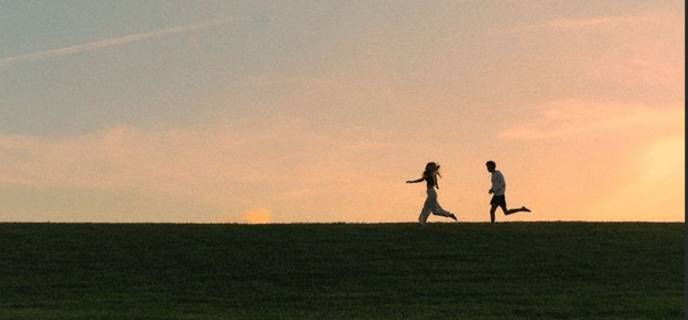 Spratt, A. (t.y.). Silhouette of two people running on a hill at sunset. Unsplash.