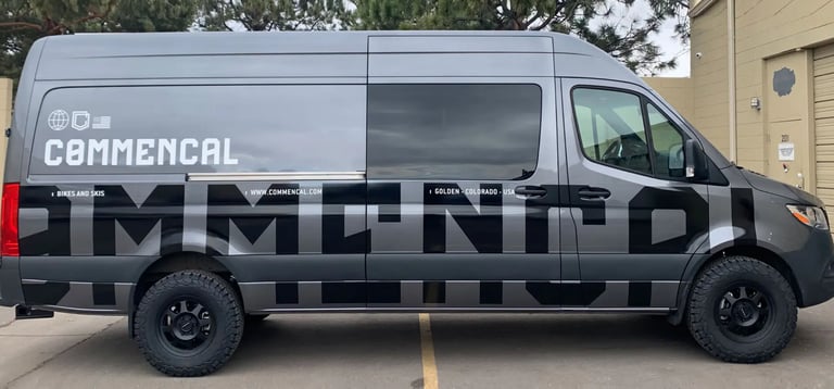 a van with a commercial vehicle WRAP parked in front of a building