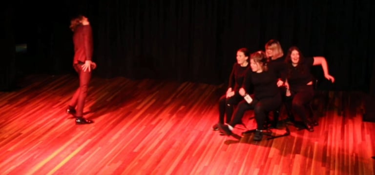 a man standing on a stage with a woman on a skateboard