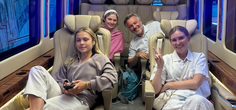 Group of four smiling passengers enjoying a premium luxury van on rent interior with blue LED lights