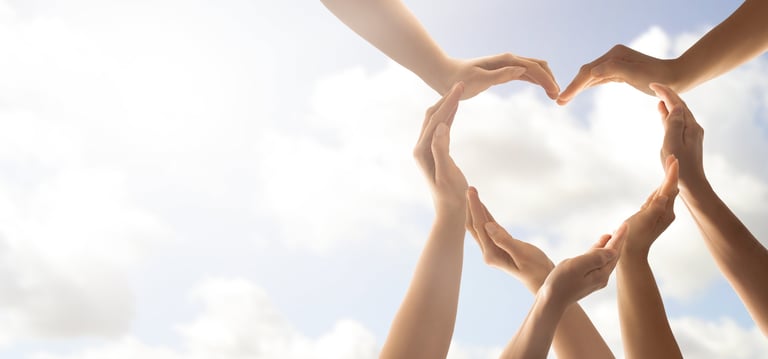a group of people holding hands in a heart shape