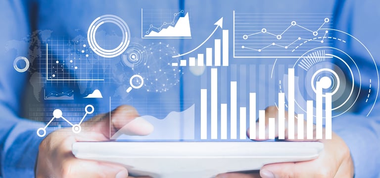 Professional in a blue shirt holding a tablet displaying futuristic data visualization charts and business analytics.