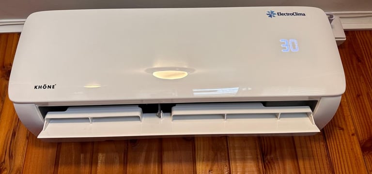 a white air conditioner sitting on a wooden floor