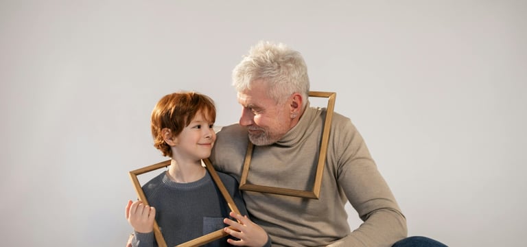 a man and a child are holding frames in front of a white wall