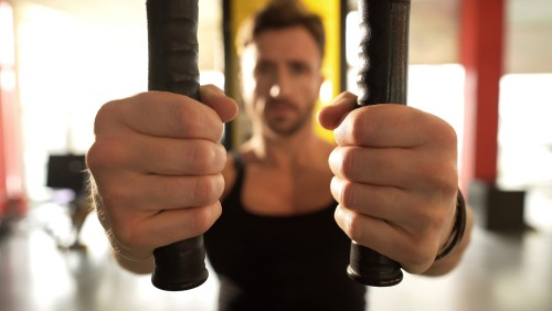 A man performs a chest fly workout on a cable machine at the gym for strength training.