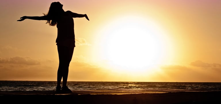 a woman standing on a dock with her arms outstretched out to the water