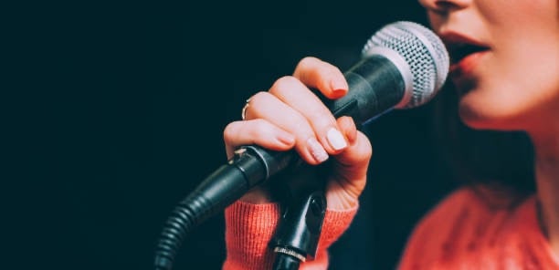 a woman in a red sweater and a microphone