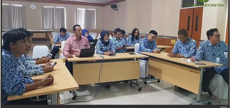 a group of people sitting at desks in a room