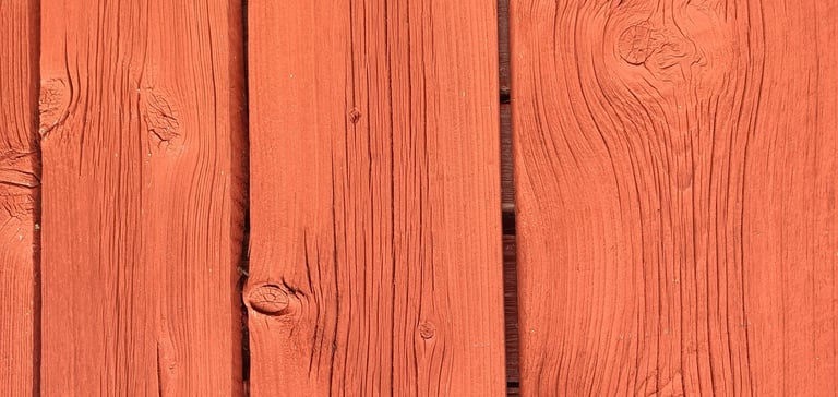 Close-up of exterior wood boards painted with breathable natural paint showing grain and knots