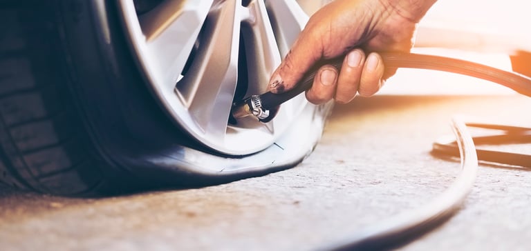 a person is checking tire pressure of a car