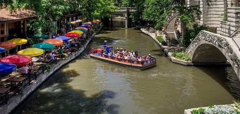 A river boat glides past restaurants on San Antonio's River Walk