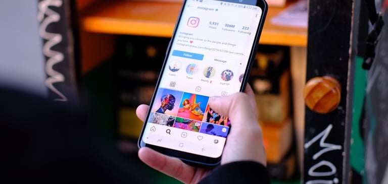 una persona sosteniendo un teléfono móvil en la mano viendo las redes sociales