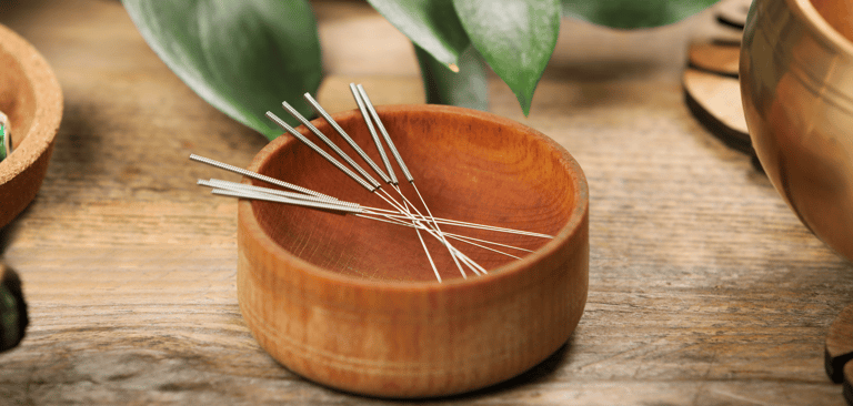 Aiguilles d'acupuncture dans un bol en bois, bol tibétain à coté