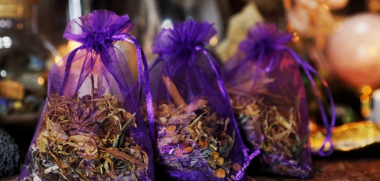 Three purple organza bags filled with herbs and flowers