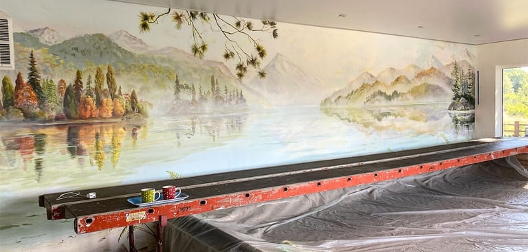 Painted panorama lake mural in progress with scaffold, showing New Zealand mountains and water view.