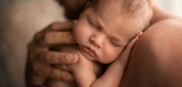 Noworodek w objęciach taty  fotografia noworodkowa.