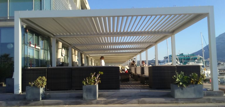 Pérgola bioclimática sobre fachada de Muro cortina.