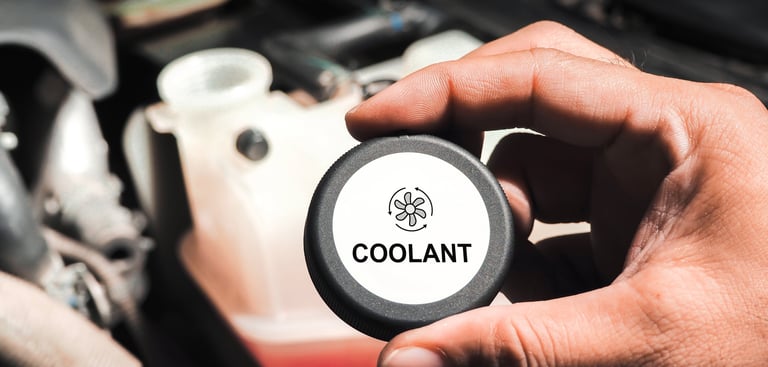 a person holding a black coolant reservoir cap