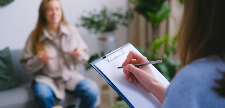 a woman in a blue shirt is holding a clipboard and a pen