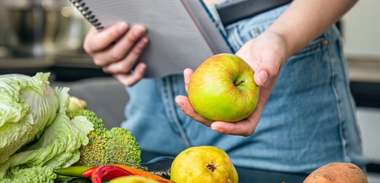 manos con cuaderno y manzana