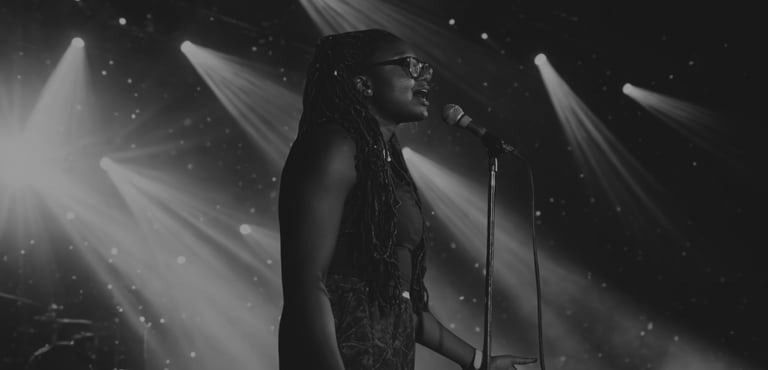 Iheoma Uzomba performing poetry on stage Vancouver