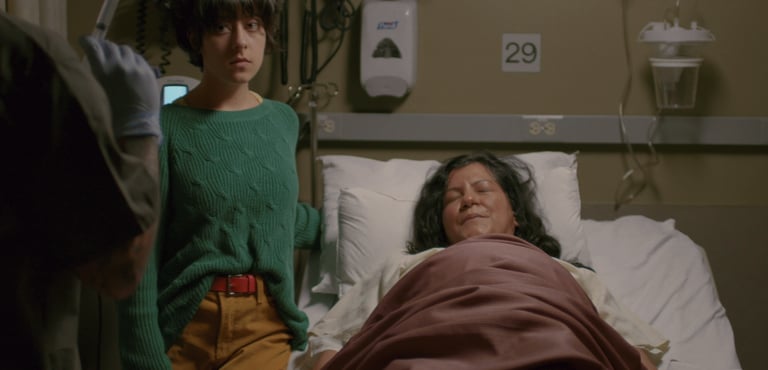 a man with dreadlocks and dreadlocks standing in front of a window