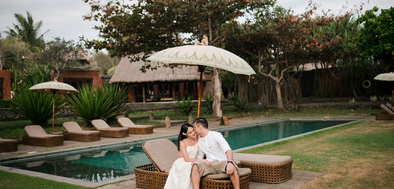 Romantic couple seated by the pool at Waka Gangga luxury resort in Tabanan Bali