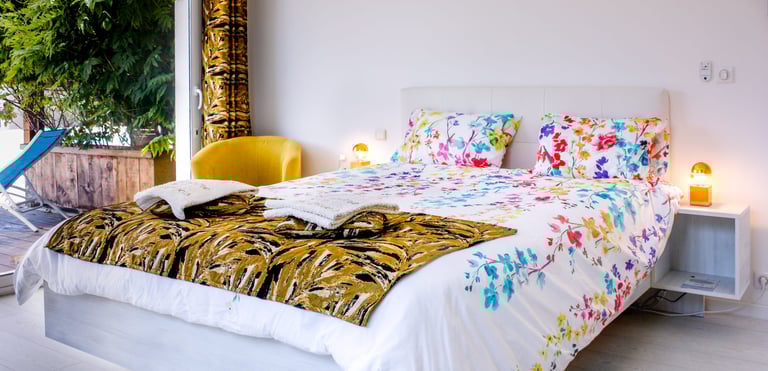 Bed with full bedding, floating bed with two with swimming pool in flower colours at Domaine Des Lucques